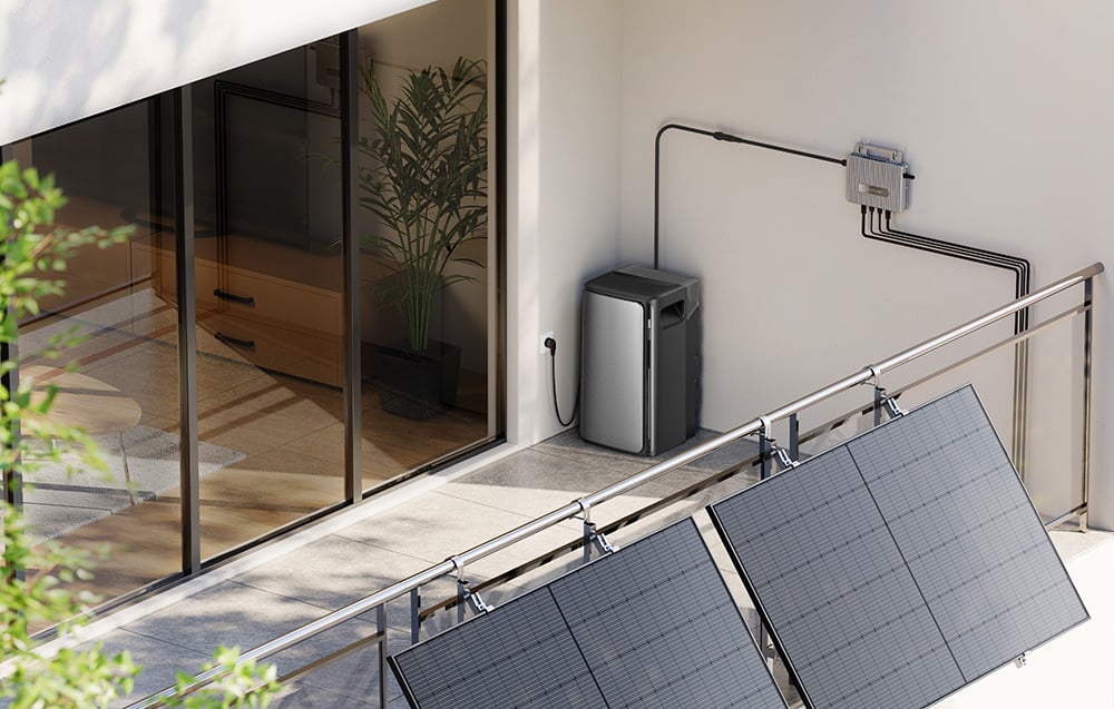 Balkon z panelami fotowoltaicznymi. Obok stoi podłączony do mikroinwertera magazyn energii.